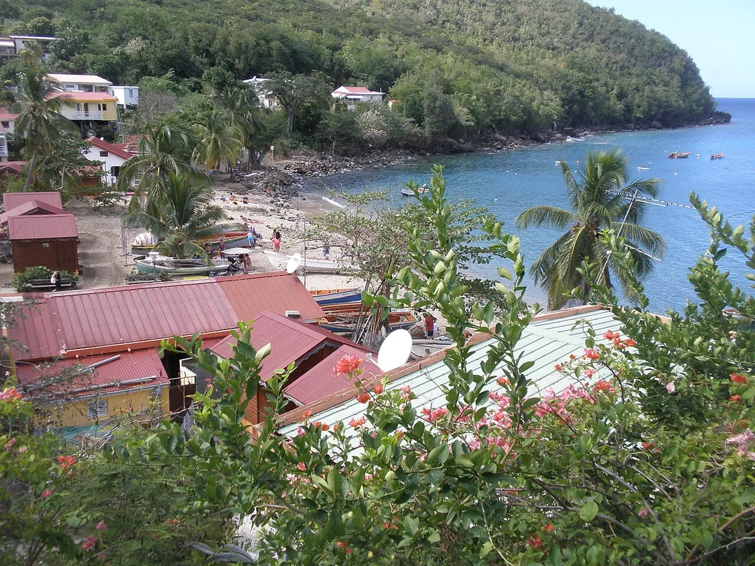 Vue plongeante sur la plage et la baie de l'Anse Dufour aux Anses-d'Arlet en Martinique, avec barques de pêche et eaux turquoise