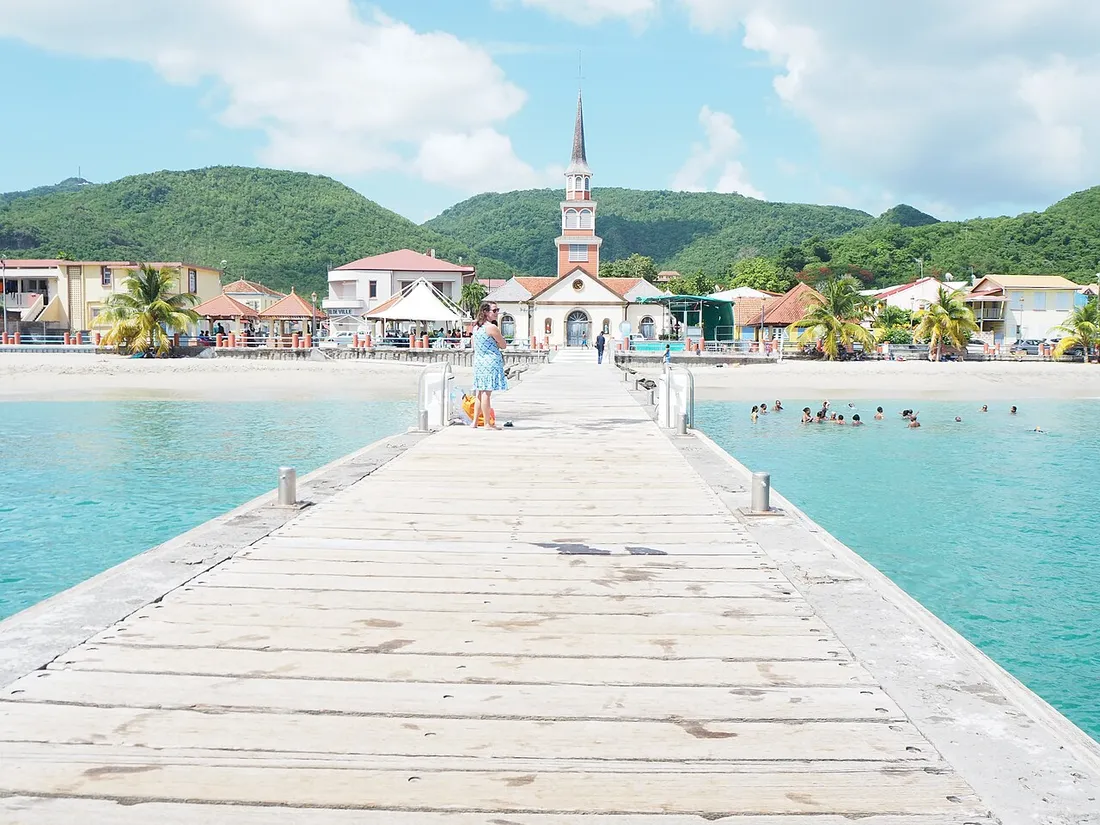 Le ponton et le bourg des Anses-d'Arlet en Martinique, avec son église face à la baie turquoise des Caraïbes