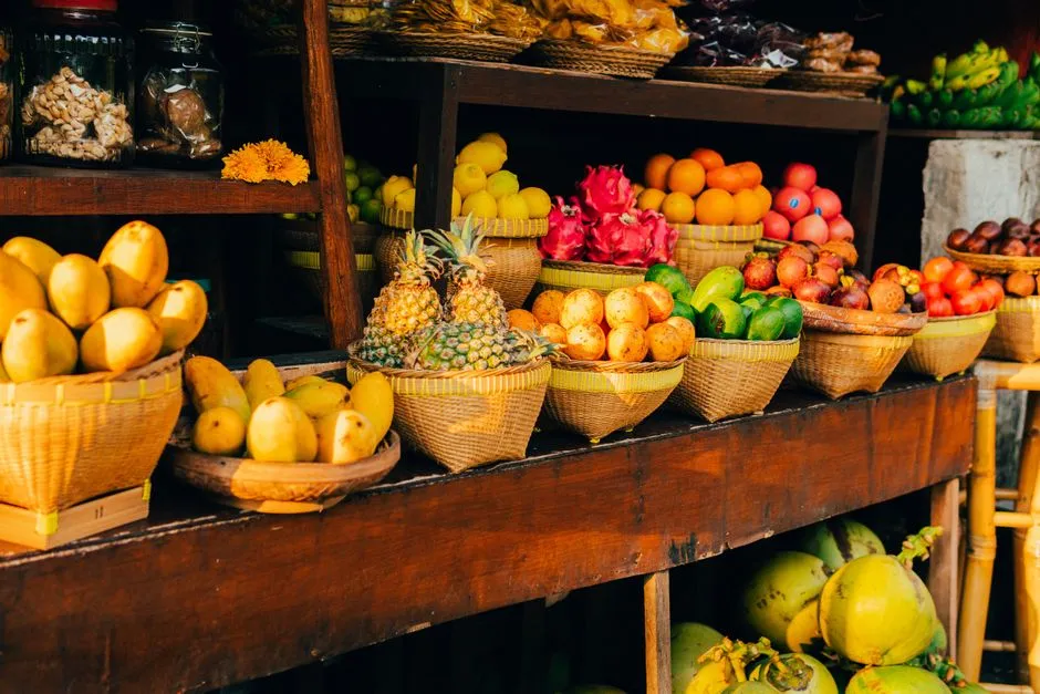 Paniers en osier garnis de fruits tropicaux varies, ananas, mangues, fruits du dragon et agrumes, presentes a la vente