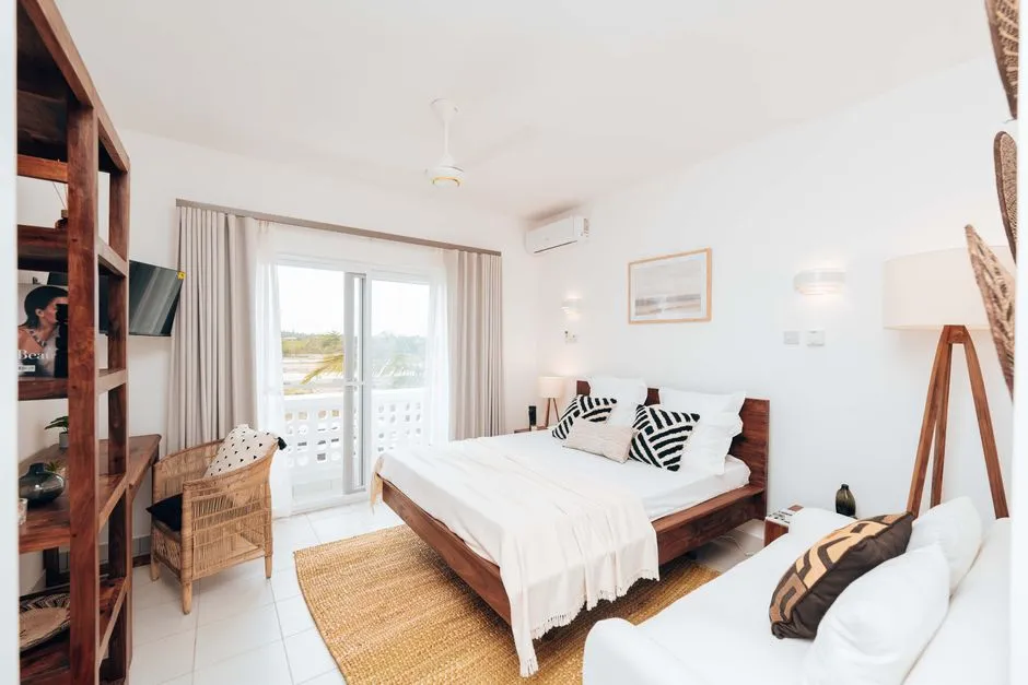 Chambre meublee lumineuse avec lit fait, balcon et vue exterieure, evoquant les prestations para-hotelieres d'un meuble de tourisme