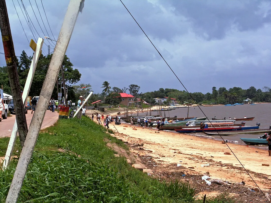 Le débarcadère d'Albina au Suriname, avec ses pirogues amarrées sur la berge sableuse du Maroni face à la Guyane