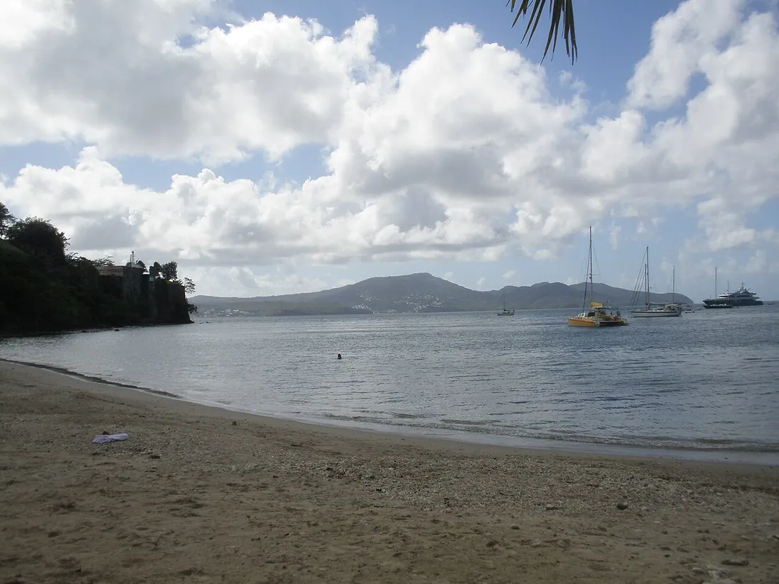 Plage de la Française à Fort-de-France en Martinique : plage de sable face à la baie, voiliers au mouillage et mornes verdoyants en arrière-plan