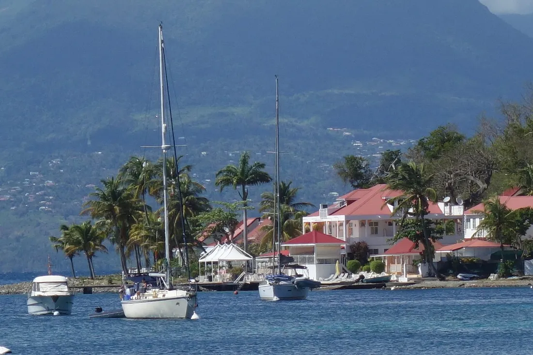 Baie de Terre-de-Haut aux Saintes en Guadeloupe, voiliers au mouillage devant des maisons créoles aux toits rouges et collines verdoyantes