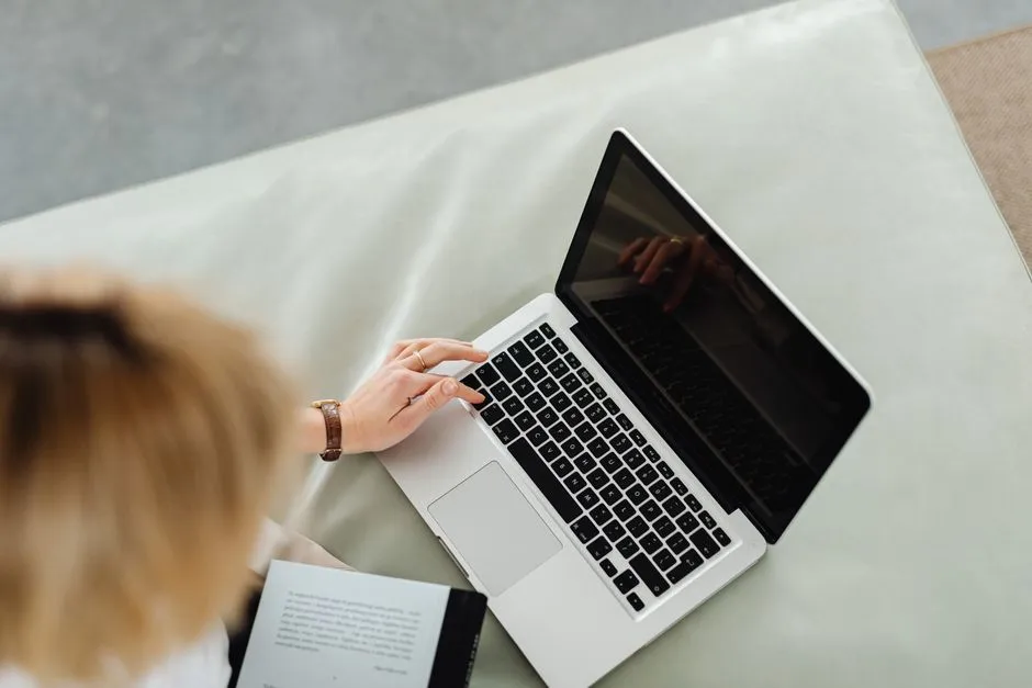 Personne assise creant une annonce de location en ligne sur un ordinateur portable, illustrant la mise en ligne d'un premier logement