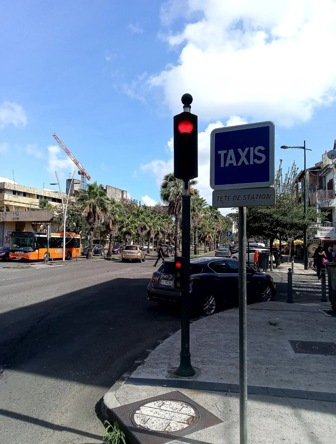 Rue animée de Pointe-à-Pitre en Guadeloupe avec station de taxis, bus et maisons créoles