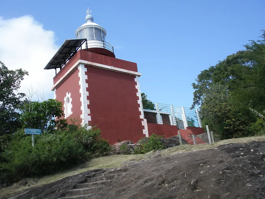 Le phare rouge de la Caravelle dressé sur les hauteurs de la presqu'île, à Tartane en Martinique, sous un ciel bleu