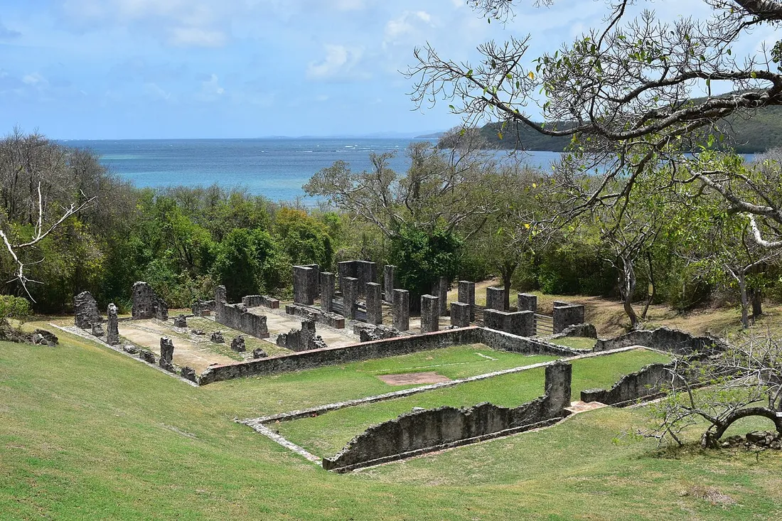 Les ruines du château Dubuc, alignements de colonnes et de murs en pierre dominant la baie turquoise sur la presqu'île de la Caravelle