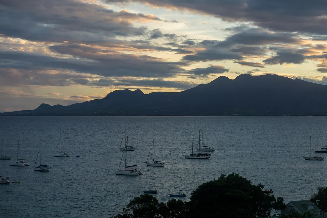 Coucher de soleil sur la baie du Gosier en Guadeloupe, voiliers au mouillage devant les montagnes