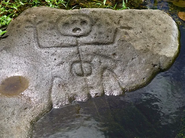 Gravure amérindienne représentant une figure anthropomorphe sculptée dans une roche au parc des Roches Gravées de Trois-Rivières en Guadeloupe