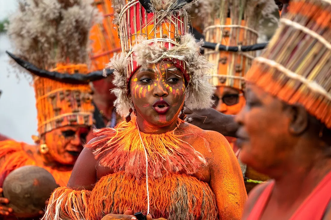 Danseurs en costumes orange à plumes lors de la grande parade du Carnaval de Guyane à Cayenne