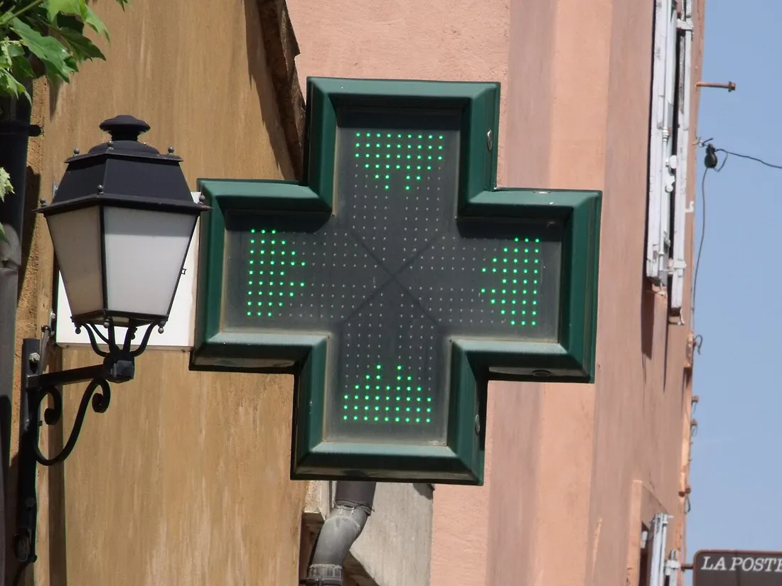 Croix verte lumineuse d'une pharmacie sur la façade d'un bâtiment