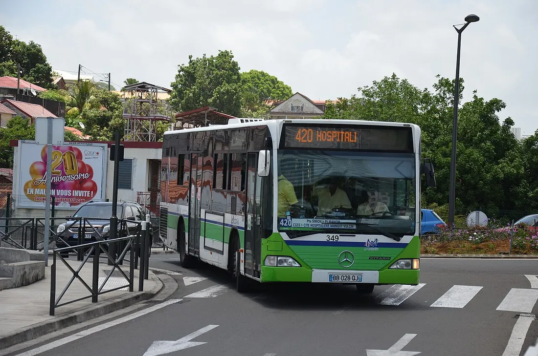 Bus urbain vert et blanc du réseau Mozaïk en Martinique, ligne 420 vers l'hôpital, circulant sur un rond-point à Fort-de-France