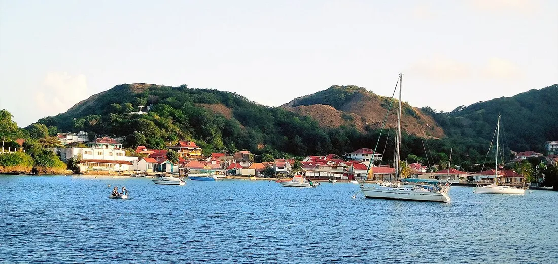 Le bourg de Terre-de-Haut des Saintes en Guadeloupe, ses maisons aux toits rouges et ses voiliers ancrés dans la baie
