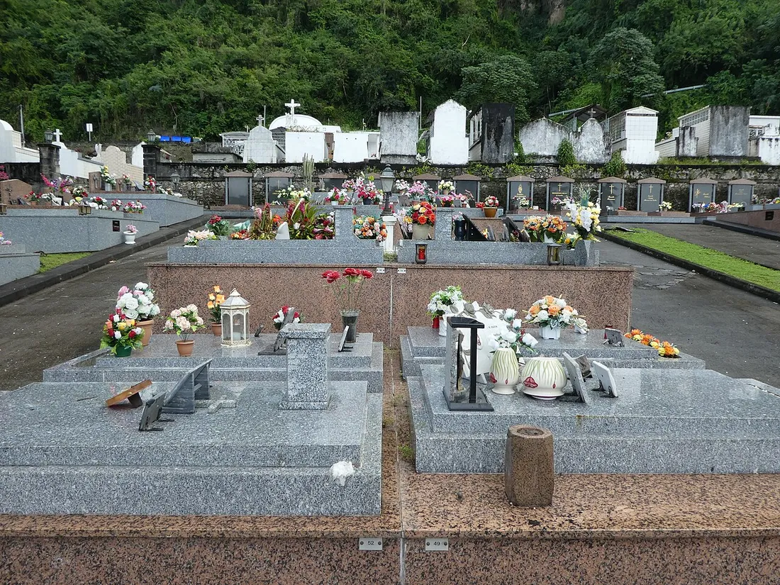 Tombes en granit fleuries et lanterne dans un cimetière de Saint-Pierre en Martinique, décoré pour la Toussaint