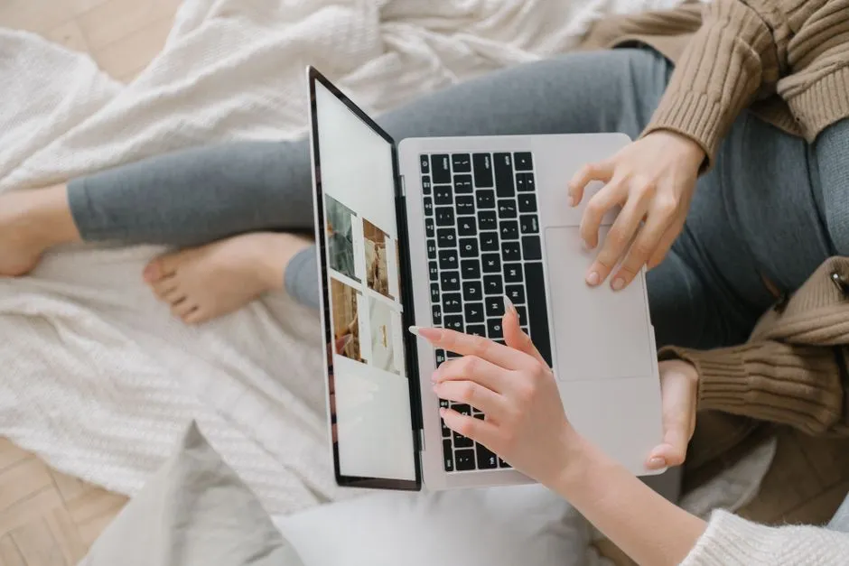 Personne assise chez elle consultant des annonces de logements en photos sur un ordinateur portable