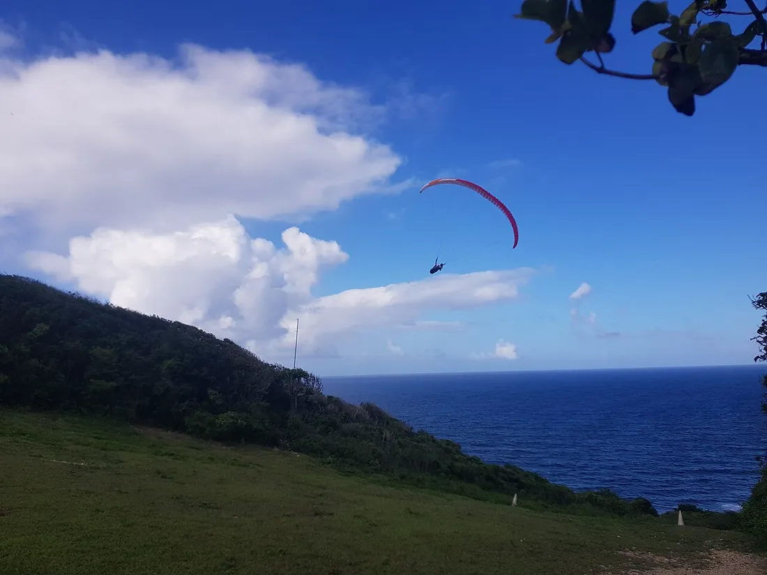 Parapente en vol au-dessus de la mer depuis l'aire de décollage de Bois-Baron, au Moule, en Guadeloupe