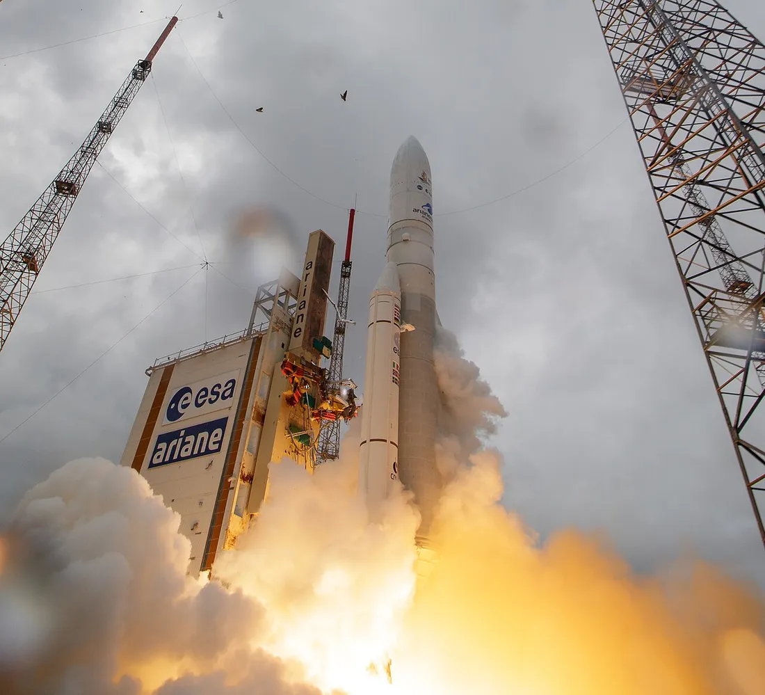 Decollage d'une fusee Ariane depuis le Centre Spatial Guyanais a Kourou, panache de feu et de fumee au pied du pas de tir