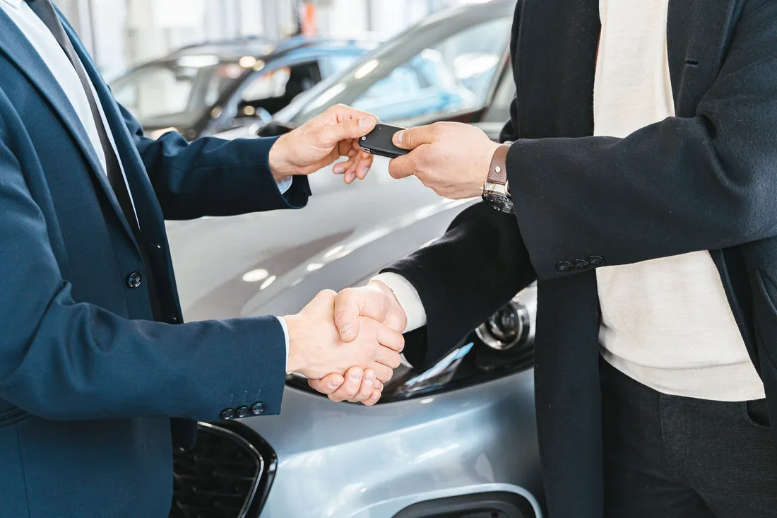 Poignée de main et remise des clés lors de l'achat d'une voiture en concession