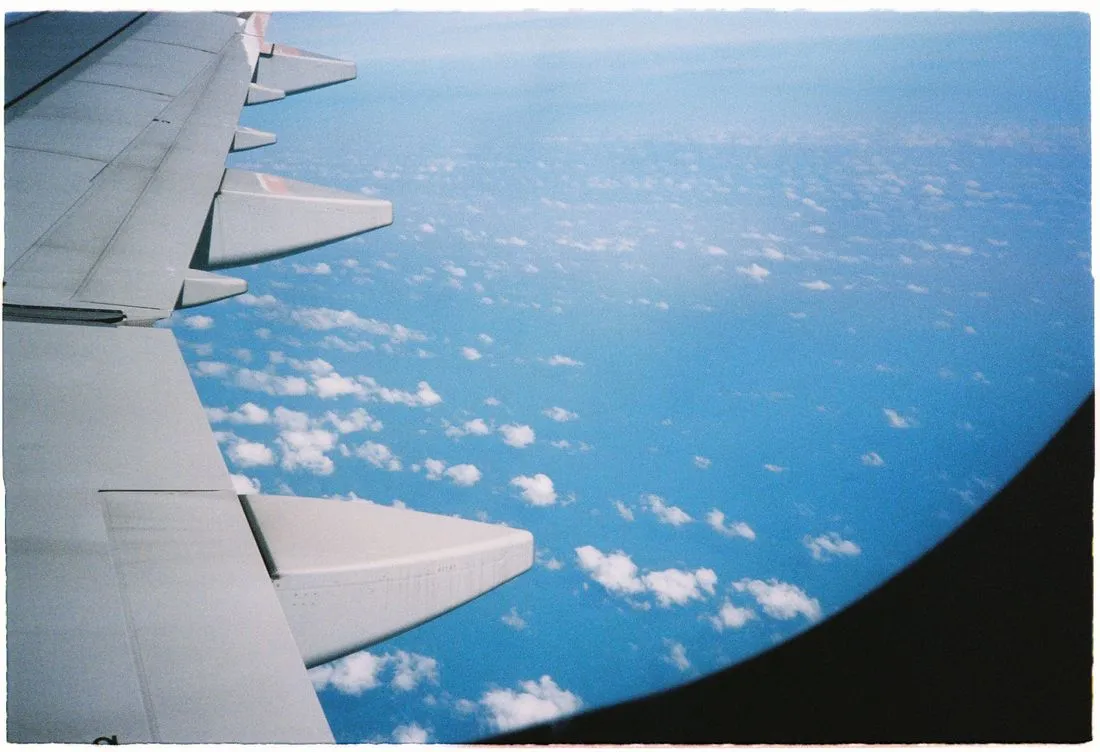 Aile d'un avion de ligne survolant une mer de nuages au-dessus de l'ocean, comme sur le long-courrier reliant Paris a Cayenne