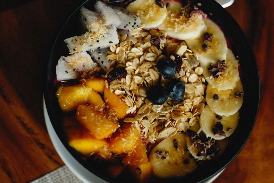 Bowl de superfruits vu de dessus mêlant açaï, banane, mangue, fruit du dragon et myrtilles prêt à déguster